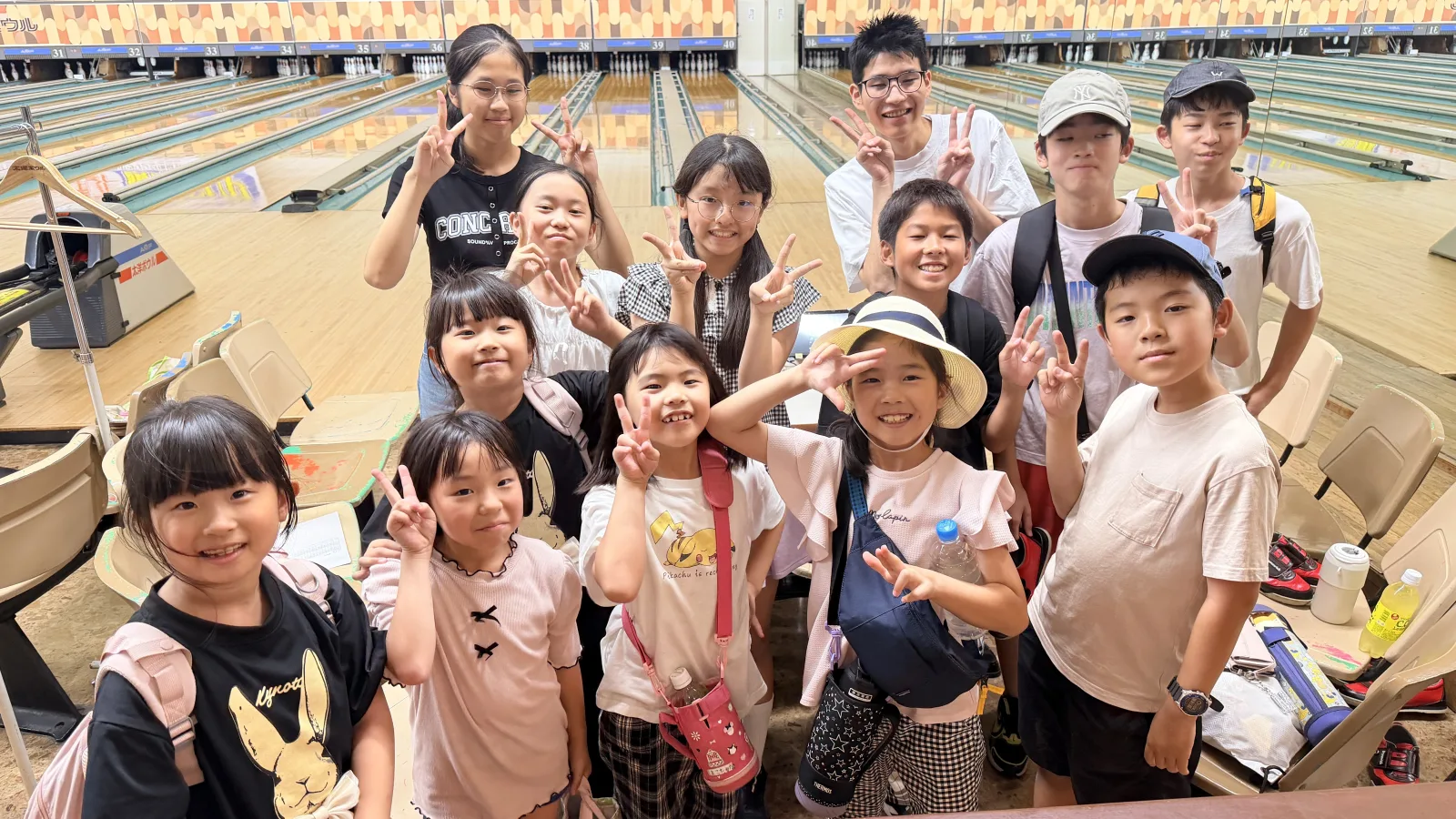ボウリング場に集まったクローネ学園の塾生たち。小学生から中学生まで、みんなで笑顔を見せている。